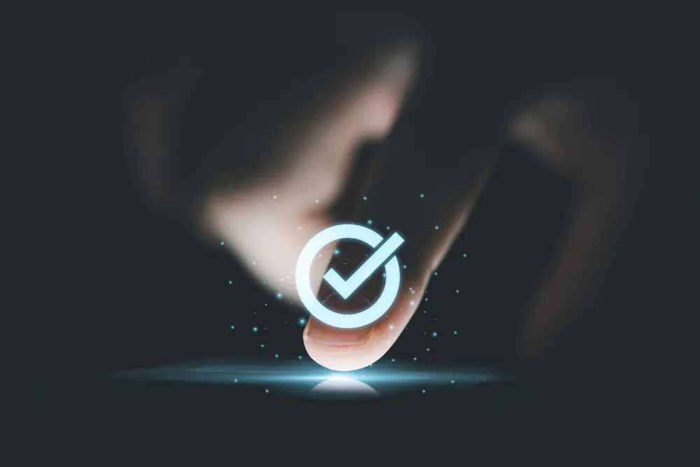 dedo pressionando um botão no celular com uma marca de seleção na parte superior