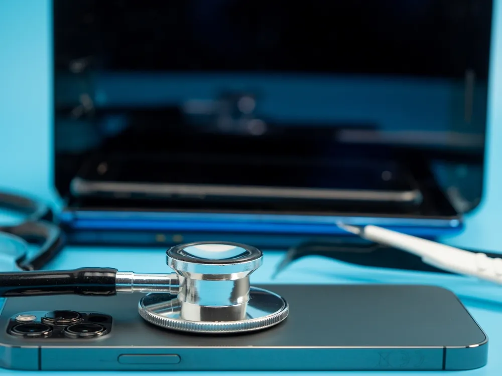 estetoscópio em um celular próximo a um computador de mesa
