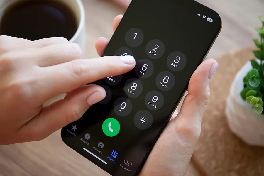 Dedo pressionando as teclas de um iPhone 14
