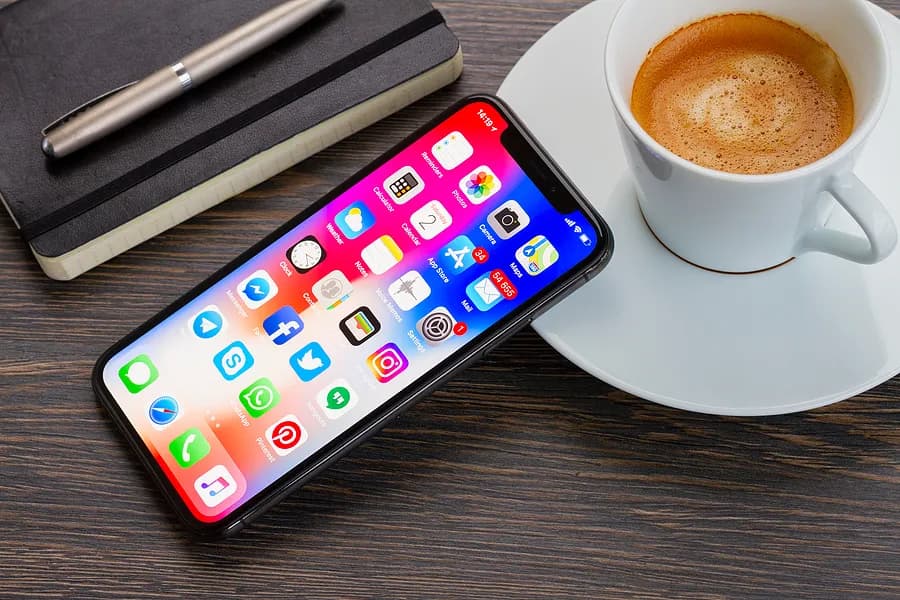 iPhone encostado em uma xícara de café