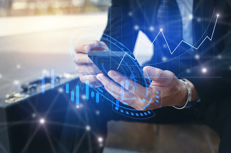 Empresário usando um smartphone com gráficos financeiros digitais sobrepostos
